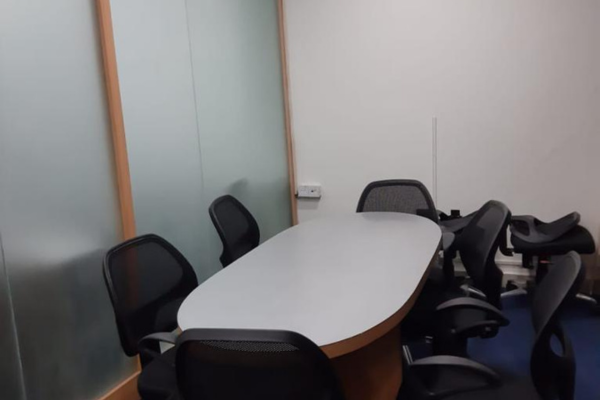 Professional meeting room with a large oval table and multiple chairs at Infinity Business Centre, perfect for collaborative discussions.