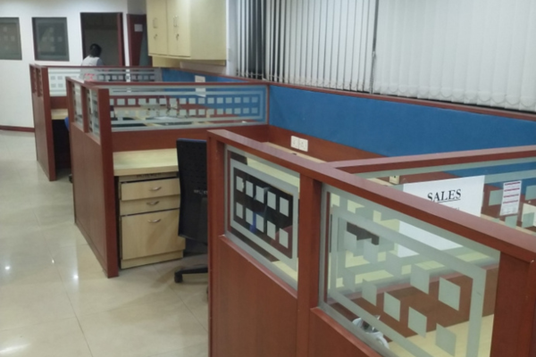 Private, fully-furnished office cubicles at Infinity Business Centre, featuring wooden finishes and frosted glass partitions, designed to provide a focused and professional work environment for individuals and teams.